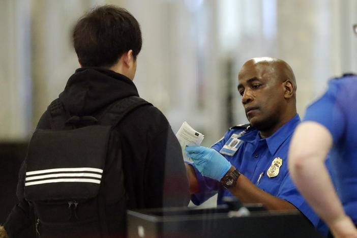 A Transportation Security Administration employee checks an air traveler's identification at Hartsfield Jackson Atlanta International Airport Monday, Jan. 7, 2019, in Atlanta.