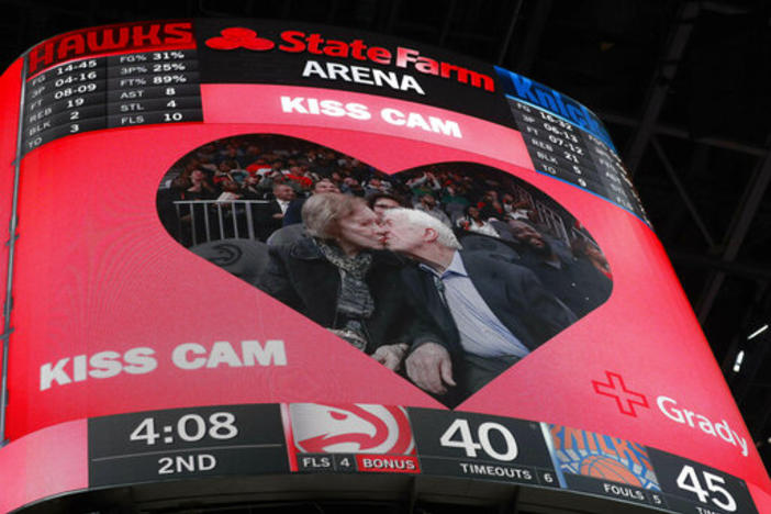 Former President Jimmy Carter kisses his wife, Rosalynn, after the two were spotted by the 'kiss cam" during the first half of an NBA basketball game between Atlanta Hawks and the New York Knicks Thursday, Feb. 14, 2019, in Atlanta.