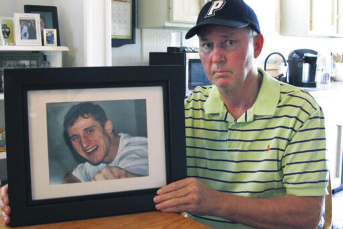 Dean Palozej poses with a photo of his son, Spencer, in Stafford, Conn. Spencer Palozej died of a fentanyl overdose in 2018.