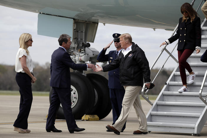 President Donald Trump, with first lady Melania Trump, is greeted by Georgia Gov. Brian Kemp and his wife Marty, as they arrive on Air Force One at Lawson Army Airfield, Fort Benning, Ga., Friday, March 8, 2019.