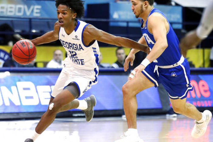 Georgia State guard Kane Williams (12) drives past Texas-Arlington guard DJ Bryant (2) during the second half of the NCAA college basketball championship game of the Sun Belt Conference men's tournament in New Orleans, Sunday, March 17, 2019.