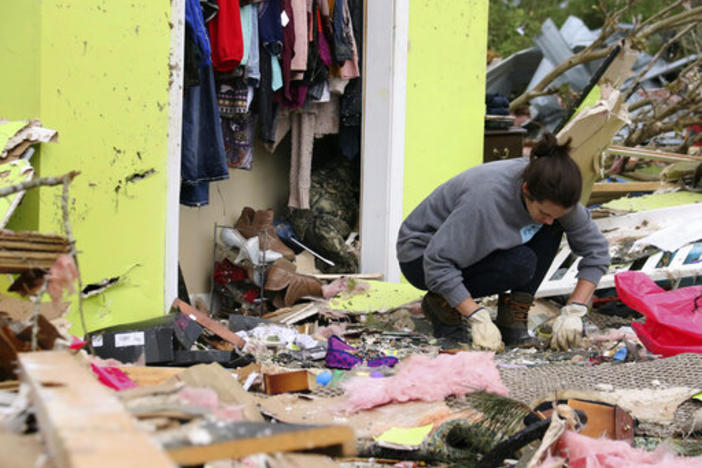 Leslie Harrington kneels down to help a former neighbor and family friend look for jewelry in her destroyed home along Seely Drive outside of Hamilton, Miss., after a deadly storm moved through the area on Sunday, April 14, 2019.