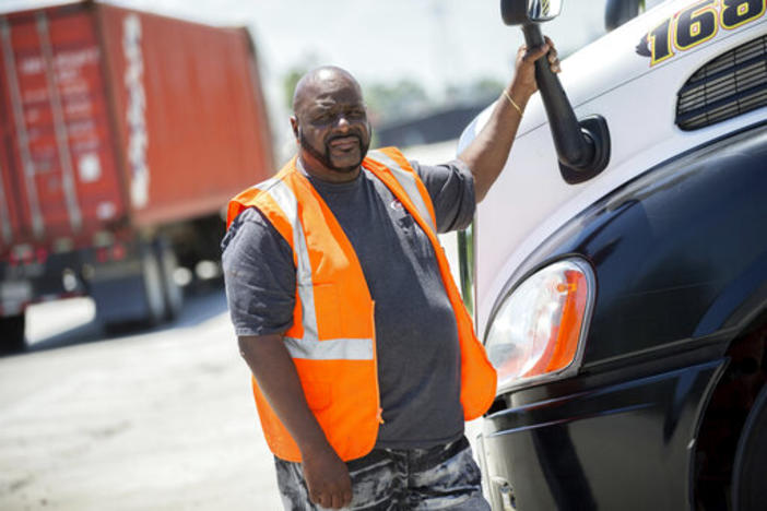 Leon Brown stands by his tractor-trailer after making a delivery from a distribution center to the Port of Savannah, in Garden City. 
