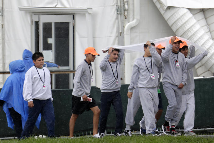 Migrant children walk on the grounds of the Homestead Temporary Shelter for Unaccompanied Children, Sunday, June 16, 2019, in Homestead, Fla. A coalition of religious groups and immigrant advocates said they want the Homestead detention center closed.