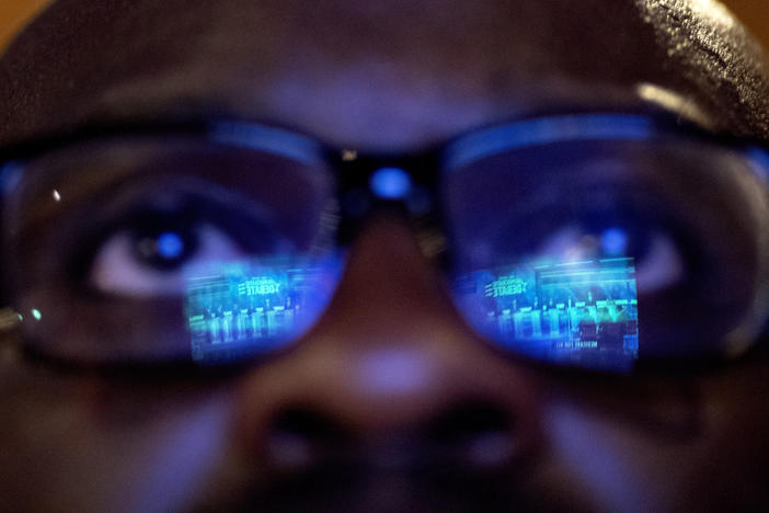 Offei Koram watches a broadcast of a Democratic presidential debate at a bar in Atlanta on Thursday, June 27, 2019.