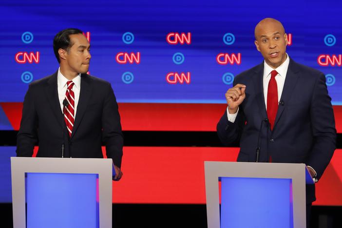 Former Housing and Urban Development Secretary Julian Castro listens as Sen. Cory Booker, D-N.J., speaks during the second of two Democratic presidential primary debates hosted by CNN Wednesday, July 31, 2019, in the Fox Theatre in Detroit. 