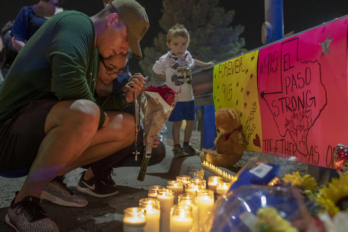 Rene Aguilar and Jackie Flores pray at a makeshift memorial for the victims of Saturday's mass shooting at a shopping complex in El Paso, Texas, Sunday, Aug. 4, 2019. 
