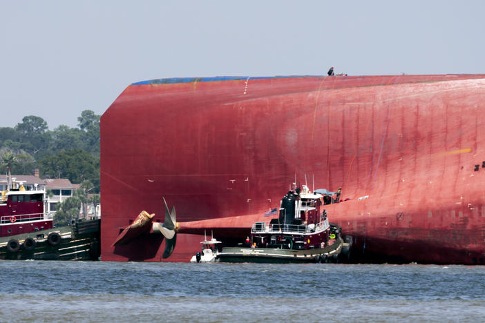 Rescuers work near the stern of the vessel Golden Ray as it lays on its side near the Moran tug boat Dorothy Moran, Monday, Sept. 9, 2019, in Jekyll Island, Ga.