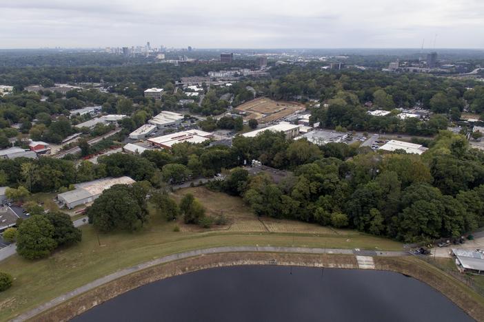 Homes and businesses sit downhill from Reservoir No. 1, a 180 million gallon water supply that has been out-of-service much of the past few decades, Tuesday, Oct. 15, 2019, in Atlanta. The city made repairs and brought it back online in 2017, only to shut