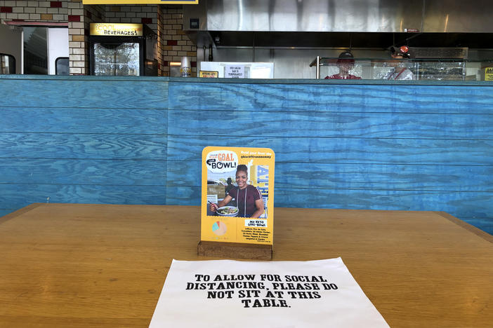 A social distancing label is affixed to a table at a local restaurant, Thursday, March 19, 2020, in Kennesaw.