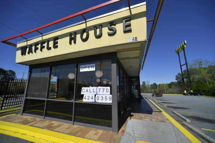 Signage is posted on the inside windown of a Waffle House restaurant, near Kennesaw State, Wednesday, March 25, 2020, in Kennesaw, Georgia. The Norcross-based chain is ready to reopen this week.