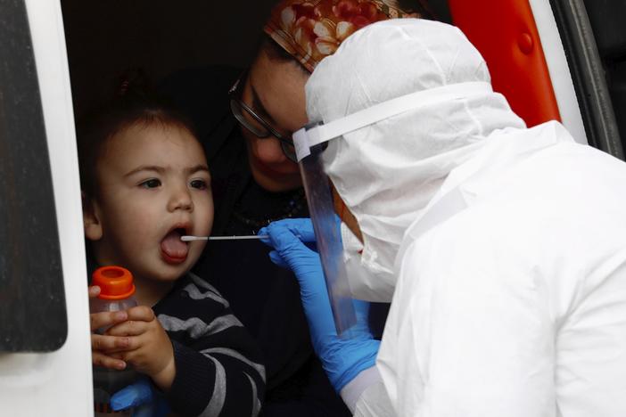  A boy receives a COVID-19 test by a medical personnel wearing protective gear as part of the government's measures to stop the spread of the coronavirus in the orthodox city of Bnei Brak, a Tel Aviv suburb, Israel, Tuesday, March 31, 2020.