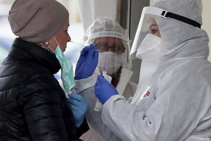 Employee of a private medical firm takes a coronavirus test sample from a health care employee in an action organized in one of Warsaw's districts to help diagnose the spread of the virus, in Warsaw, Poland, Wednesday, April 15, 2020. 