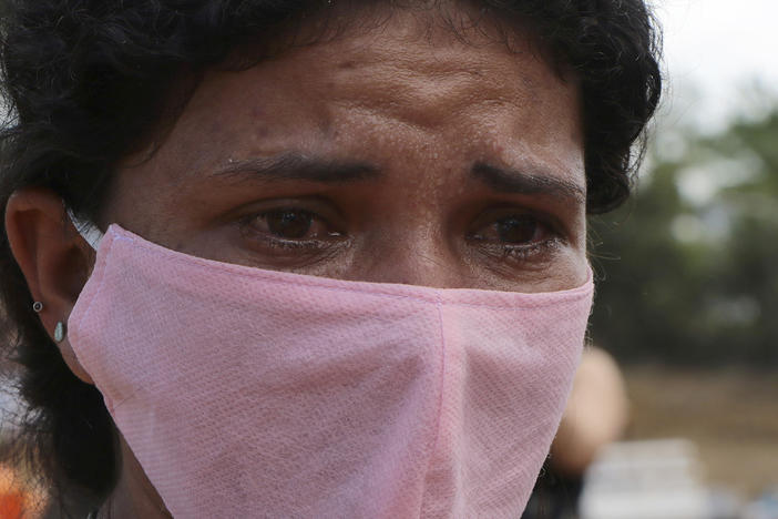 A woman mourns at the site of a mass burial at the Nossa Senhora Aparecida cemetery, in Manaus, Amazonas state, Brazil, Tuesday, April 21, 2020. 