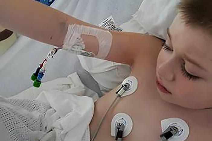 Bobby Dean lies in a hospital bed in Rochester, N.Y., after being admitted with severe dehydration, abdominal pain and a racing heart. He tested positive for coronavirus at the hospital and the doctors diagnosed him with a pediatric inflammatory syndrome.
