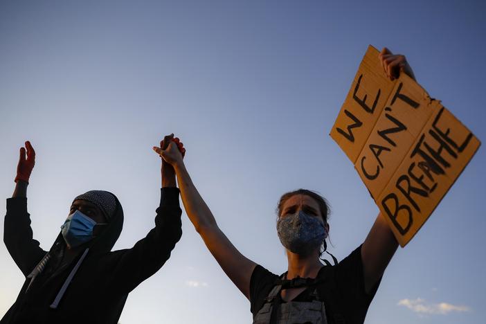 Protesters demonstrate on University Avenue while holding a "WE CAN'T BREATHE" sign, Thursday, May 28, 2020, in St. Paul, Minn. Protests over the death of George Floyd, a black man who died in police custody Monday, broke out for the third straight night.