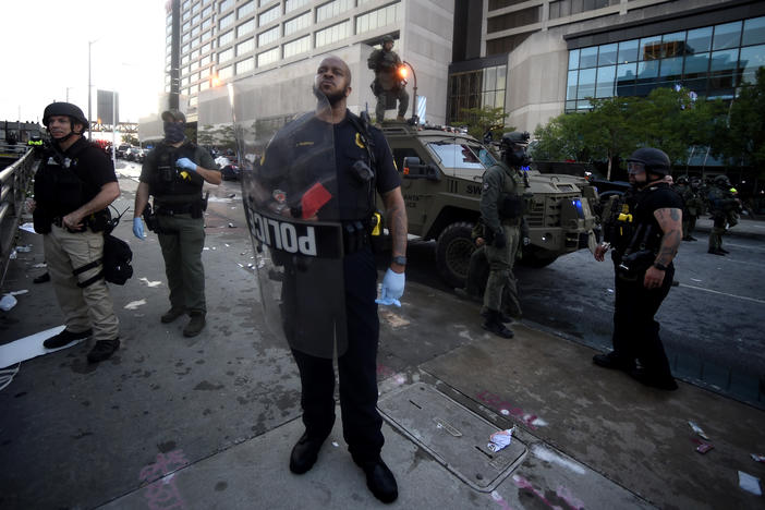 An Atlanta police officer stands near where police officers and protesters clashed near CNN Center, Friday, May 29, 2020 in Atlanta. The protest started peacefully earlier in the day before demonstrators clashed with police.