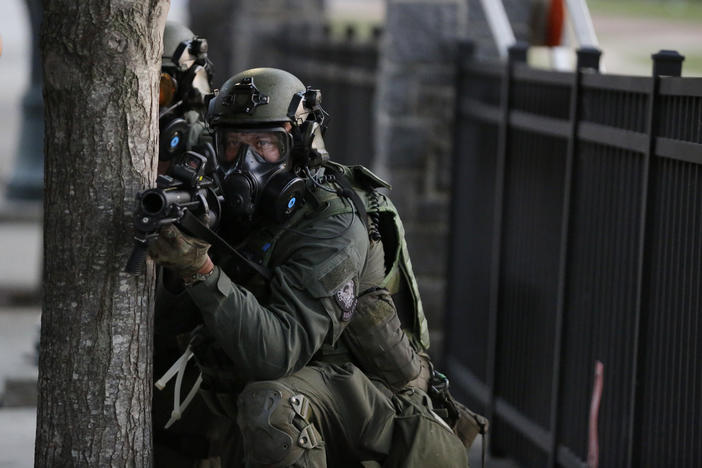 Police prepare to shoot gas as demonstrators march, Sunday, May 31, 2020, in Atlanta. Protests continued following the death of George Floyd, who died after being restrained by Minneapolis police officers on May 25.