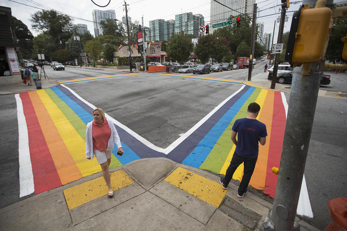 Pedestrians cross a rainbow painted crosswalk in midtown to commemorate the annual Atlanta Pride Parade.
