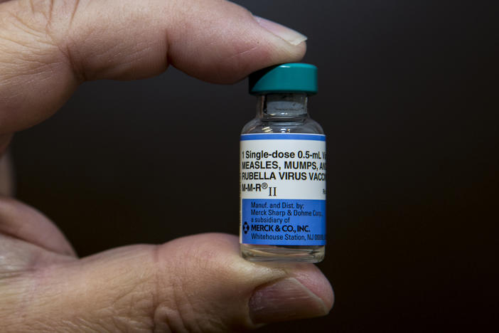 In this Thursday, Jan. 29, 2015 photo, pediatrician Charles Goodman holds a dose of the measles-mumps-rubella, or MMR, vaccine at his practice in Northridge, Calif. The vaccine is 99 percent effective at preventing measles, which spreads easily.