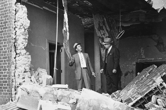 Det. Supt. I. G. Cowan, right, and Det. W. K. Perry examine dynamite ruins after an explosion at a Jewish temple in Atlanta on Oct. 13, 1958. No one was injured.