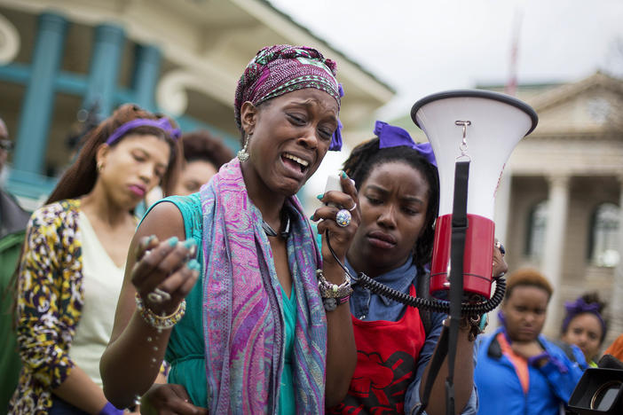 Omega Menders cries as she speaks to protesters demonstrating the shooting death of 27-year-old Anthony Hill by a police officer, Wednesday, March 11, 2015, in Decatur, Ga. Robert Olsen faces prison time when he is sentenced on four charges Nov. 1, 2019.