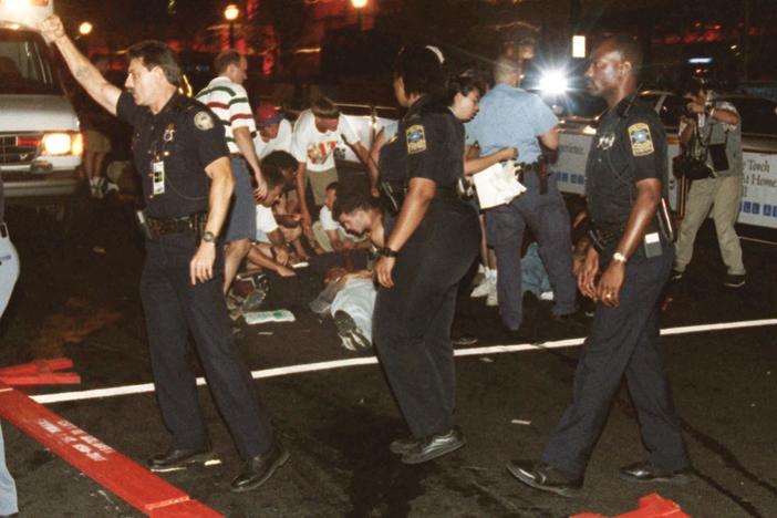 Emergency personnel and volunteers surround an injured person after an explosion in Atlanta's Centennial Olympic Park early Saturday morning July 27, 1996. 
