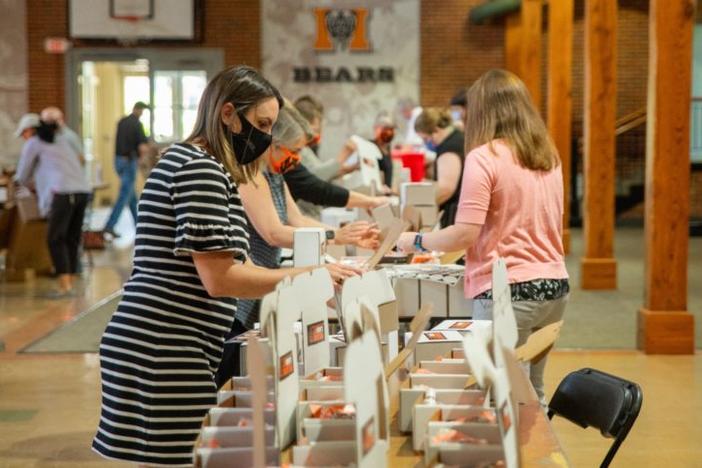 Volunteers from Mercer University assemble Bears Care kits to hand out to students attending summer classes. Students returning in the fall will also receive the kits.