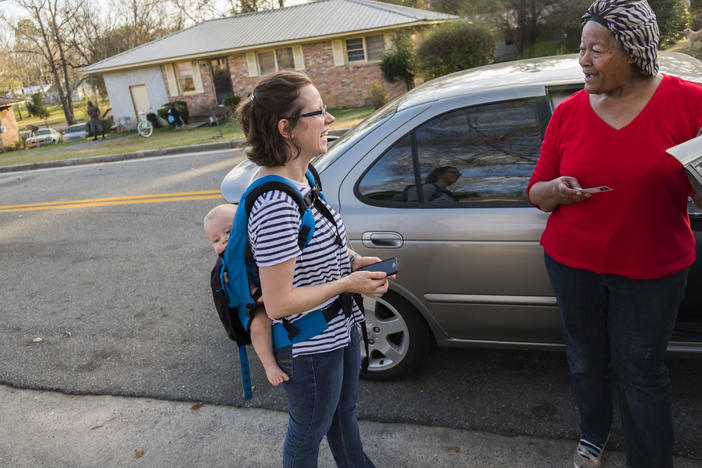 Cheyenne Warnock, left, carrying one of her four children, talks with Shirley Home during Warnock's first day of door to door canvassing in Cochran in her run for a Georgia legislative seat. 