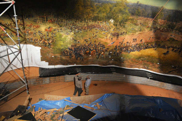 Gordon Jones (left) shows off the painting to a Atlanta History Center donor.
