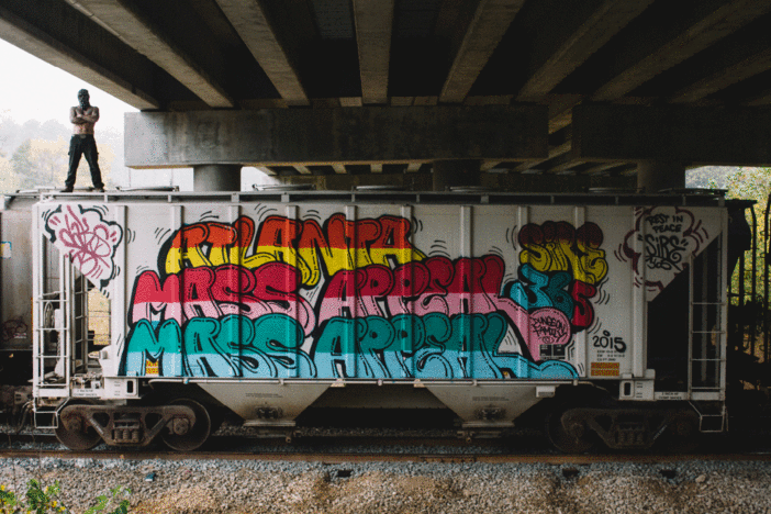 Dr. Dax stands atop a freight car decorated with his work.
