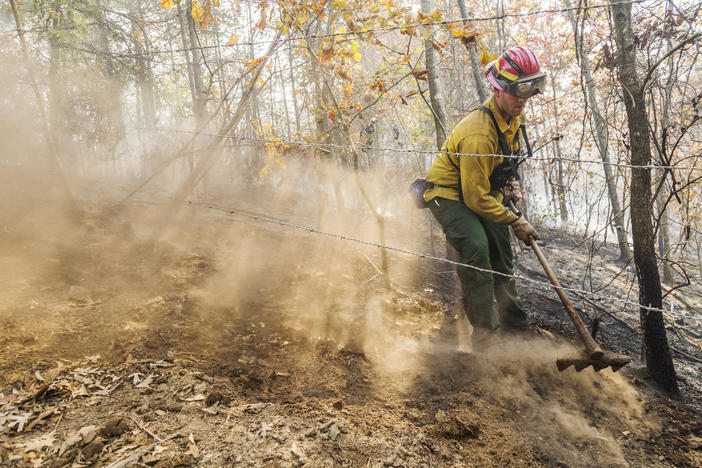 Georgia Forestry Commission ranger Eric Evans uses a fire rake to get flammable material both above and below ground out of the way of a fire in Gordon County Georgia. 
