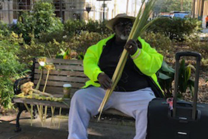 James Pringle weaves reed roses in Wright Square.