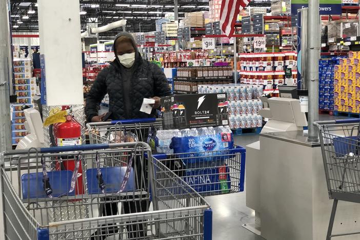 A shopper wears a face mask while buying cases of water at a Sam's Club in Woodstock Wednesday, March 4, 2020.
