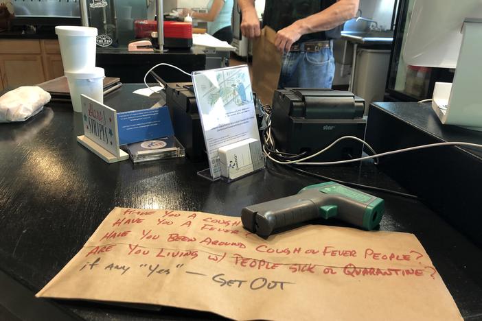A no-touch thermometer device sits at the ready for customers picking up orders at the Crazy Cuban restaurant near midtown Atlanta.