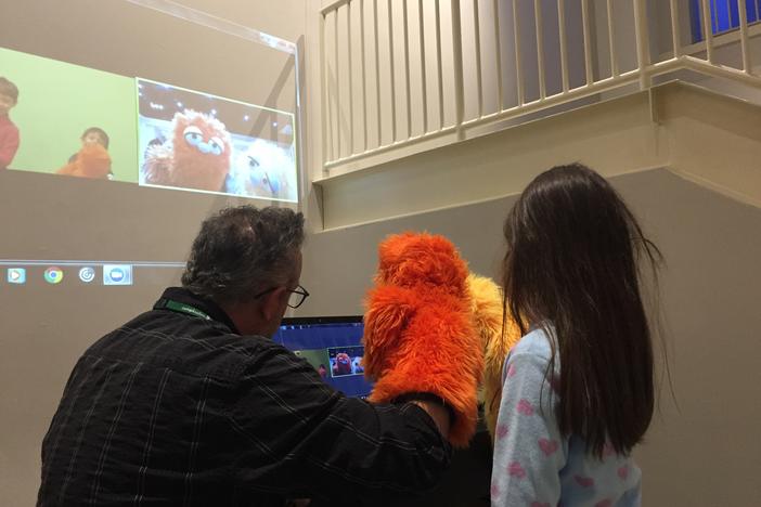 The orange puppet's name is Satsuma. He's one of the characters that used to show students how arts and science come together.