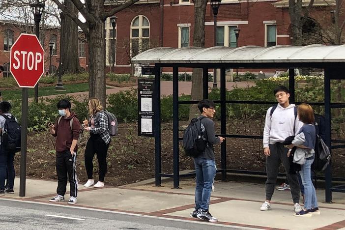Students wait for a bus as concerns about Coronavirus grow.