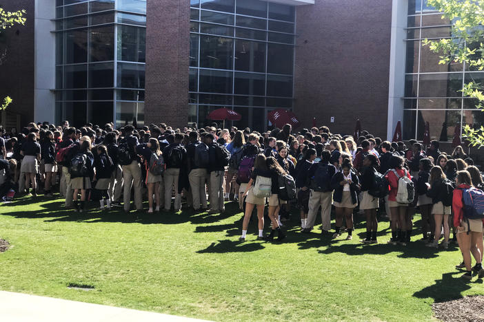 Students walk out of Woodward Academy in College Park. 