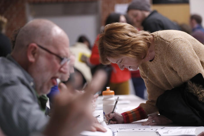 Caucus goers check in at Roosevelt High School, Monday, Feb. 3, 2020, in Des Moines, Iowa.