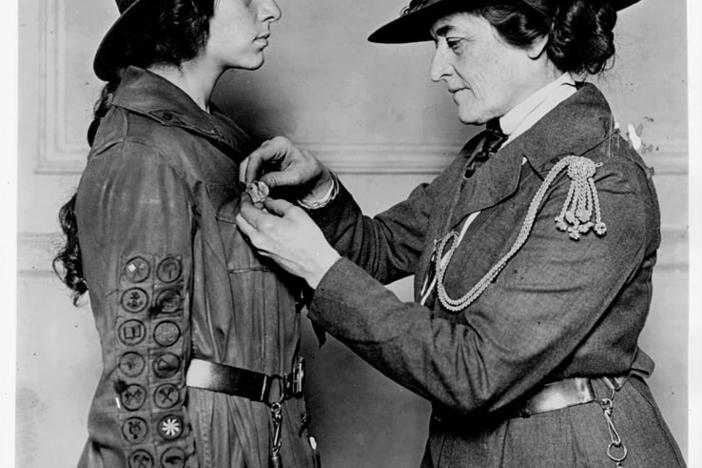 Juliette Gordon Low officiates a Girl Scout.