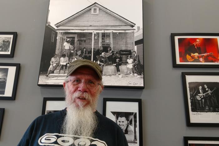 Kirk West, former Allman Brothers Band tour manager, stands in front of photographs he took of the group. West's documentary looks at the band's time at The Big House in Macon.