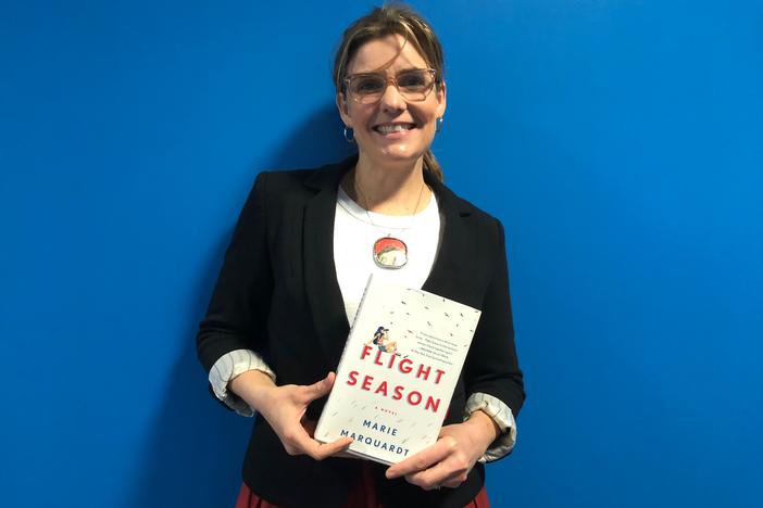 Author Marie Marquardt poses  with her novel "Flight Season" on Feb. 20, 2018.