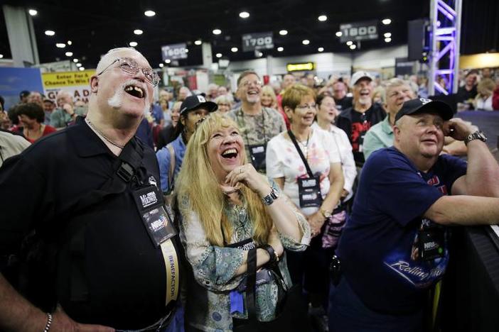 John, left, and Joe Windle, of Baltimore, watch on a television from the exhibition hall as President Donald Trump speaks at the National Rifle Association's annual convention in Atlanta, Friday, April 28, 2017.