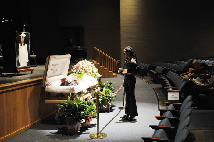 Shaquavia Woodard pauses at the casket of her former classmate Shar'Bora Yan'Kita Shyrell Daniels before Daniels' funeral in the auditorium of Central High School in Macon in 2012.