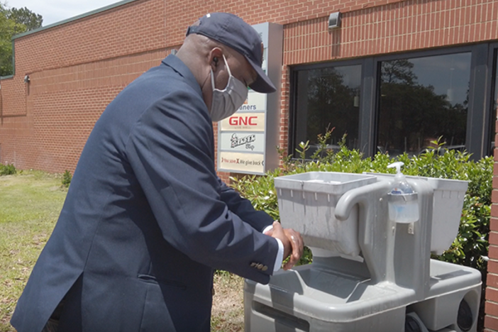 Savannah Mayor Van Johnson sports a mask and washes his hands during a May visit to Hunter Army Airfield. 