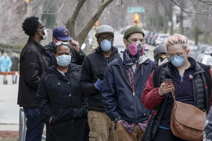 Voters masked against coronavirus line up at Riverside High School for Wisconsin's primary election Tuesday April 7, 2020, in Milwaukee. 