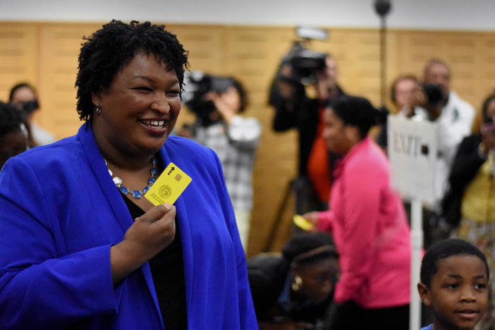 Democratic Gubernatorial Nominee Stacey Abrams returns a yellow voter access card after voting early Monday, Oct. 22 at the South DeKalb Mall.