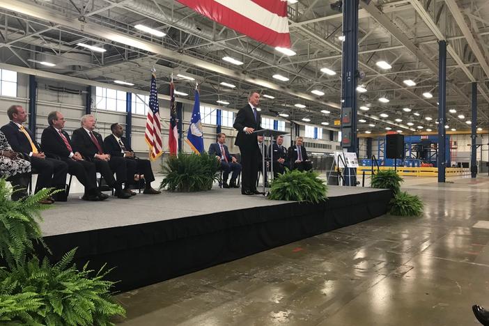 Senator David Perdue speaks to crowd at the former Boeing plant in Macon while Governor Brian Kemp and others look on