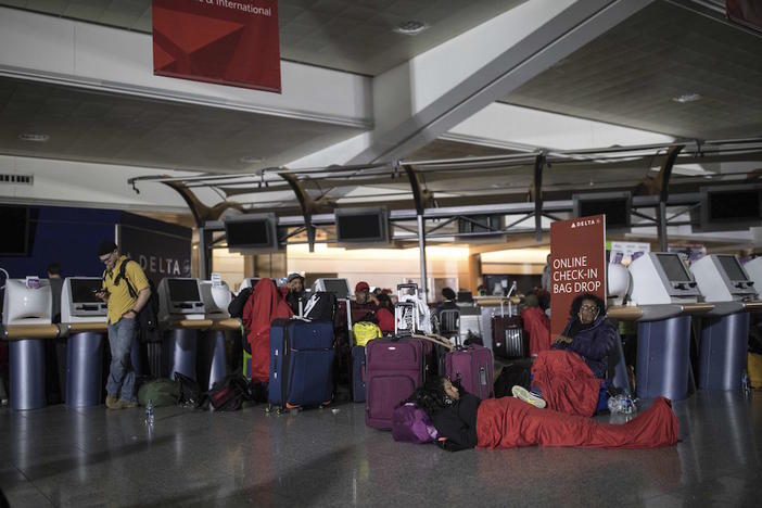 Passengers wait after the lights went out at Hartfield-Jackson Atlanta International Airport, Sunday, Dec. 17, 2017, in Atlanta. A sudden power outage at the airport on Sunday grounded scores of flights and passengers.