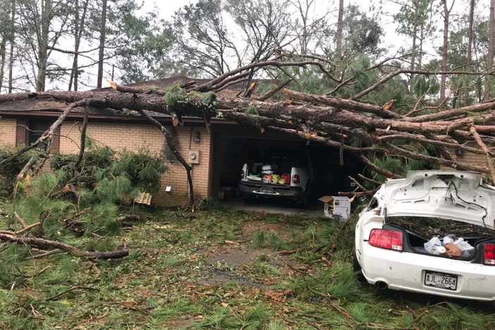 A tree rests on a home and car in Bainbridge as a result of Hurricane Michael.